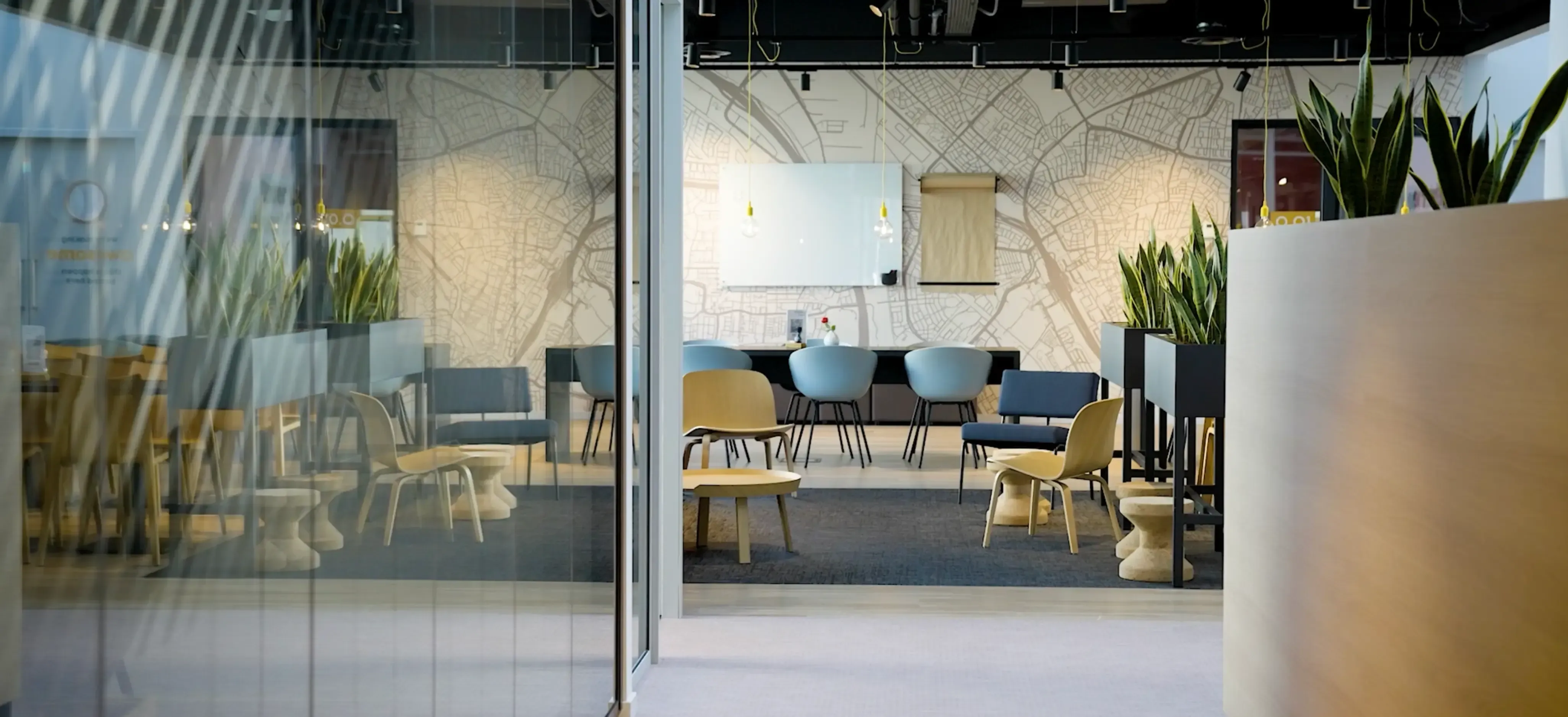 Een moderne vergaderruimte van Aristo Meeting Center in lichte, zakelijke kleuren zoals wit, blauw en houtkleuren. De ruimte bevat een whiteboard en papier om vergaderingen te ondersteunen en diverse zitopstellingen.