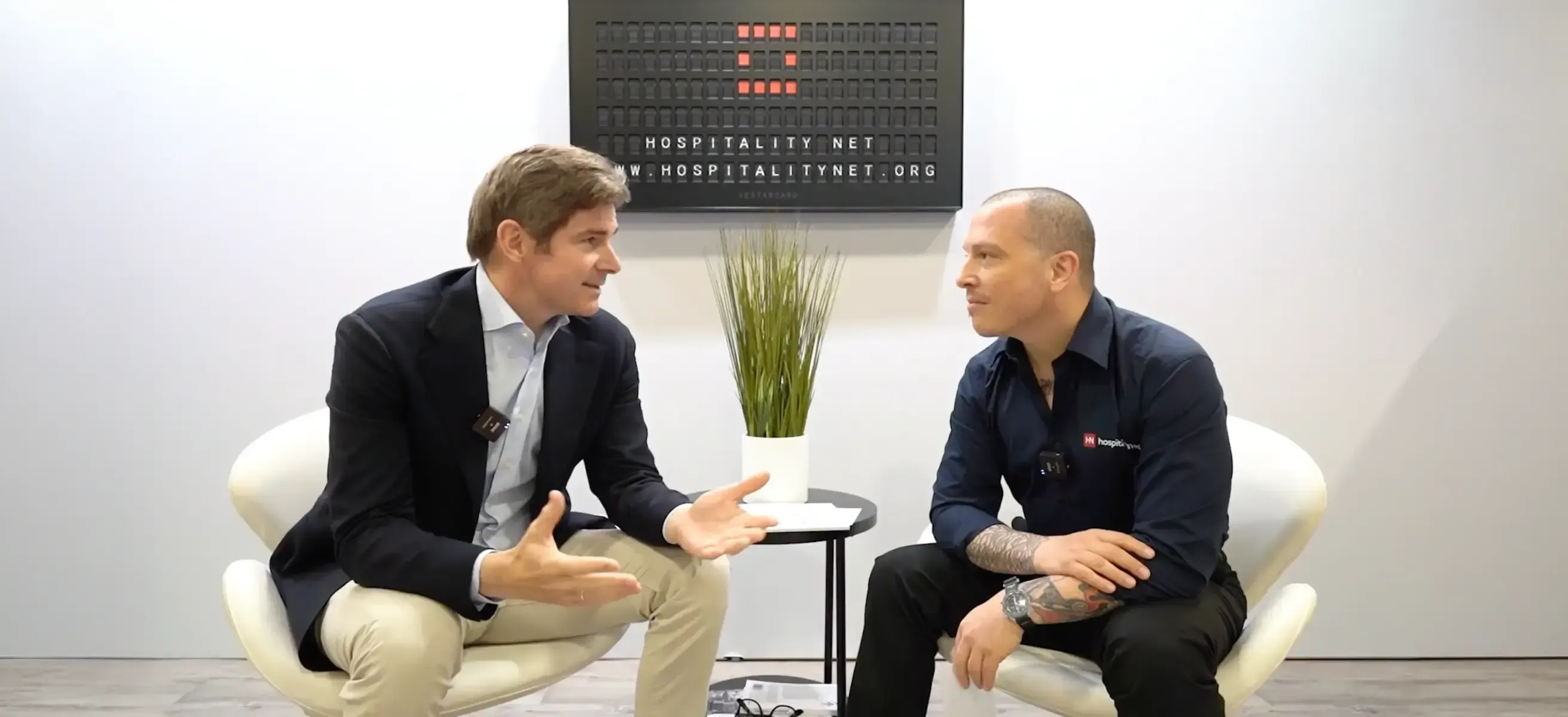 Foto van Ralph van Hooijdonk en Simone Puorto zittend op twee stoelen tijdens een interview over AI in hospitality.